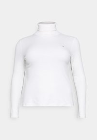 Chemise à col roulé blanc à manches longues au design ajusté. Confectionnée dans un tissu lisse, elle présente un petit logo sur la poitrine.