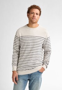Lichtbeige trui met marineblauwe horizontale strepen, geribde ronde hals, mouwen en zoom. Gemaakt van zachte stof; casual pasvorm.