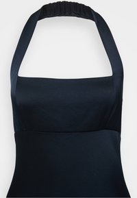 Mustatolkaiminen mekko, jossa on rakenteellinen yläosa ja sileä pinta. Sisältää leveät hihnat ja kootun yksityiskohdan kauluksessa.