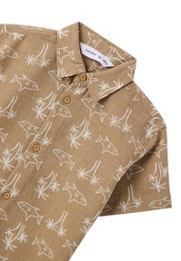 Camicia corta marrone chiaro a maniche corte con motivi bianchi di squali e palme, con colletto e bottoni marroni.