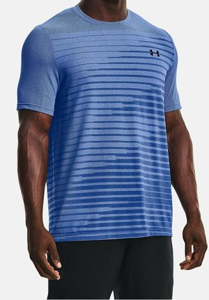 Muskularna osoba ubrana w niebieską sportową koszulkę z krótkim rękawem, z poziomymi paskami i małym czarnym logo Under Armour na piersi.