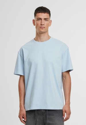 T-shirt en coton bleu clair avec des manches courtes, un col rond et une coupe décontractée. Texture lisse, sans motifs ni métal apparent.