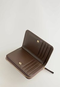 Bruine leren portemonnee met ritssluiting, voorzien van kaartsleuven en een drukknoop, met een gladde textuur en accenten van goudkleurig beslag.