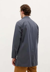 Grå, langærmet frakke med en afslappet pasform, krave og rygventilationsdetalje. Fremstillet af glat, let stof. Minimalistisk design.