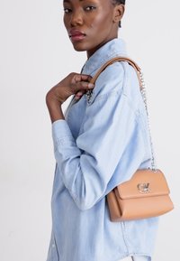Calvin Klein RELOCK SHOULDER BAG - Borsa a mano - lion