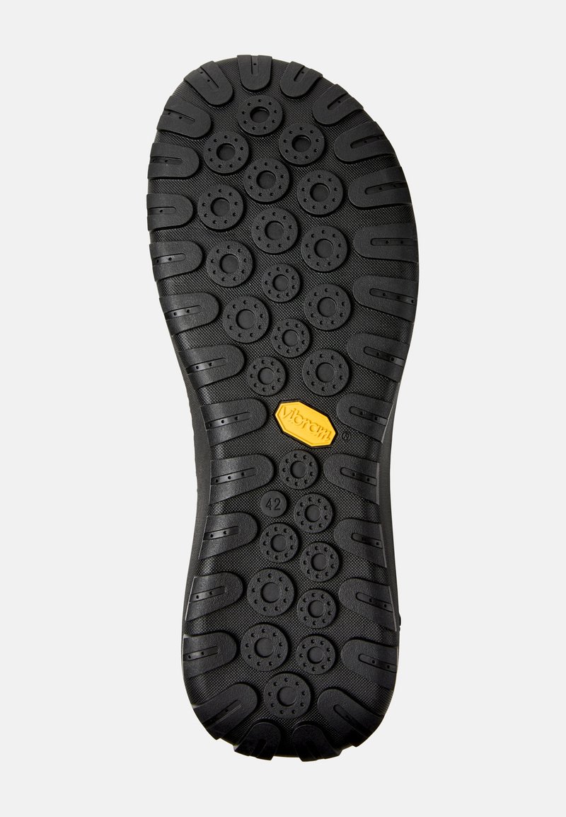 Black Vibram sole featuring a textured surface with circular treads and a hexagonal logo. Size indicated as 42 on one side.