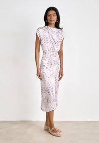 Short-sleeve, midi dress in a light, smooth fabric with a pink and purple pattern; ruched waist detail and a relaxed fit. Worn with beige flats.