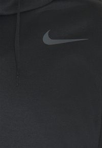 Sweat à capuche noir avec une finition texturée, arborant un logo Nike gris sur la poitrine. Comprend des cordons de serrage pour un ajustement confortable et épousant parfaitement le corps.