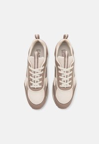 Beiga och bruna sneakers med nätmaterial, rund tå, snörning och randiga detaljer på sidorna; texturerad gummisula för bra grepp.