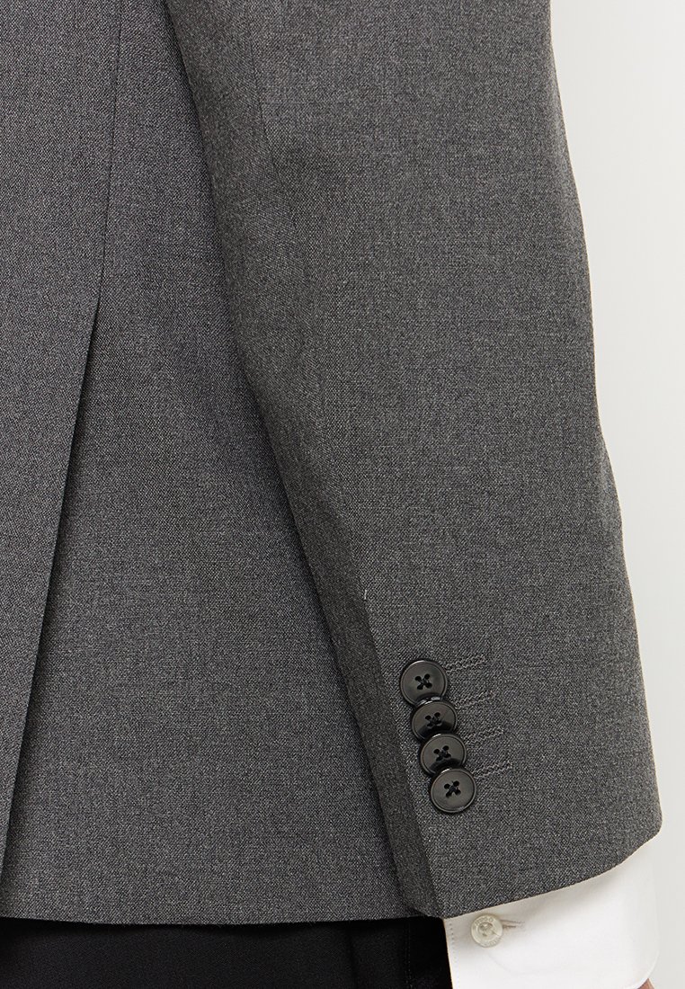 Blazer gris ajusté avec une texture lisse, présentant quatre boutons noirs sur la manche et une fente arrière unique pour un ajustement structuré.