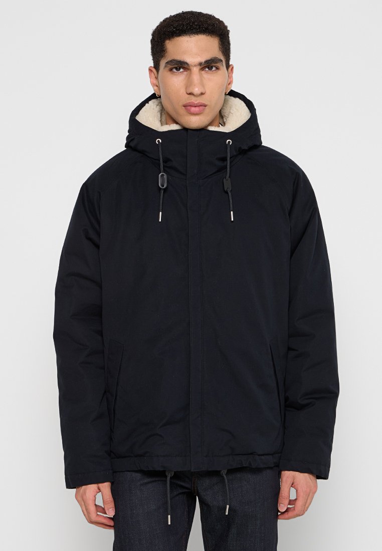 Zwarte hoodiejas met faux fur voering en verstelbare trekkoorden. Voorzien van zijzakken en een losse, casual pasvorm. Duurzaam materiaal en uniforme kleur.
