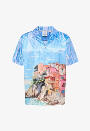 Világoskék, rövid ujjú ing tengerparti jelenettel, amely színes épületeket ábrázol. Az anyag sima textúrájú és gombos kialakítású.
