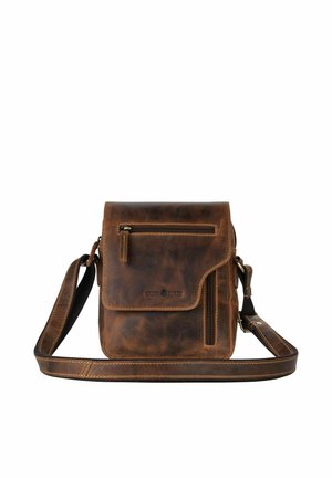 Sac bandoulière en cuir marron avec rabat avant, deux poches zippées et bandoulière réglable sur fond blanc.