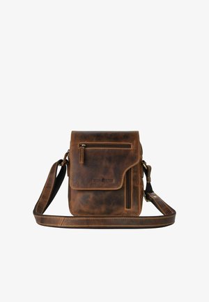 Sac bandoulière en cuir marron avec rabat avant, deux poches zippées et bandoulière réglable sur fond blanc.