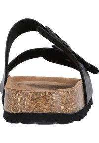 Svart sandal med korkfotbädd och svart gummiutsida; har två justerbara remmar och en slät yta.