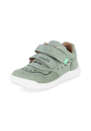 Groene kindersneaker met twee klittenbanden, witte zool, mesh tong en decoratieve zwarte stiksel-details aan de zijkanten.