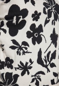 Schwarz-weißes Blumenmuster auf einem weißen Hintergrund, das verschiedene Blumenformen und Blätter in einem strukturierten Strickstoff zeigt.