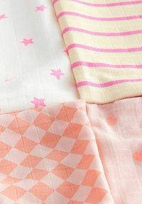 Fire stykker stof: et hvidt med pink stjerner, et gult med pink striber, og to ferskenfarvede med diamant- og hjerte-Mønstre.
