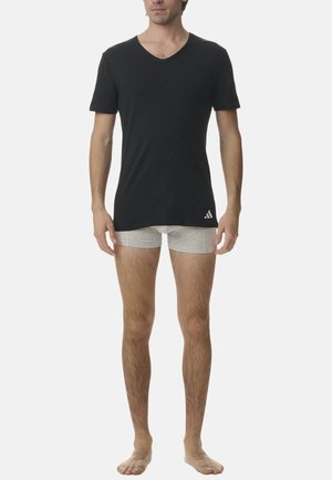 Sort V-hals t-shirt i bomuldsstof, parret med grå boxer shorts. T-shirten har et logo på den nederste venstre side.