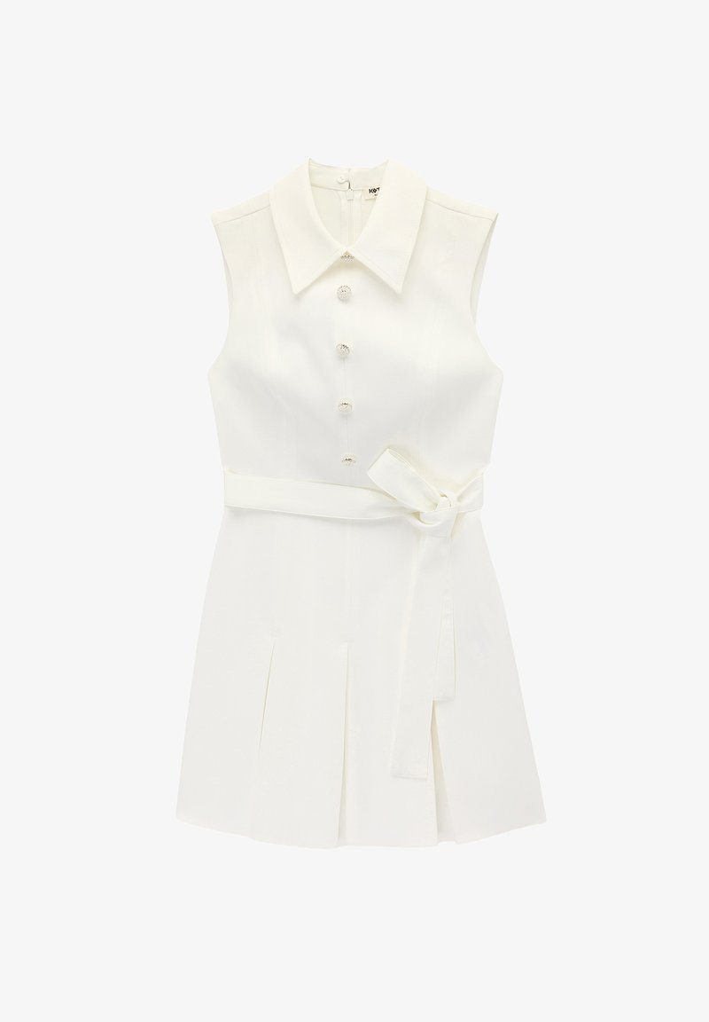 Ærmeløs hvid kjole med bred krave, dekorative knapper foran, et bundet bælte ved taljen og plisseret nederdel.