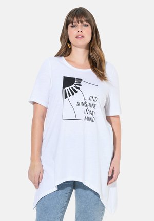 T-shirt blanc à manches courtes avec un ourlet asymétrique et un imprimé graphique noir représentant un motif de soleil et le texte "...ET DU SOLEIL DANS MA TÊTE."
