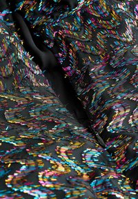 Zwarte stof met levendige, veelkleurige borduursels van draad in golvende patronen; glanzende textuur met metalen accenten.