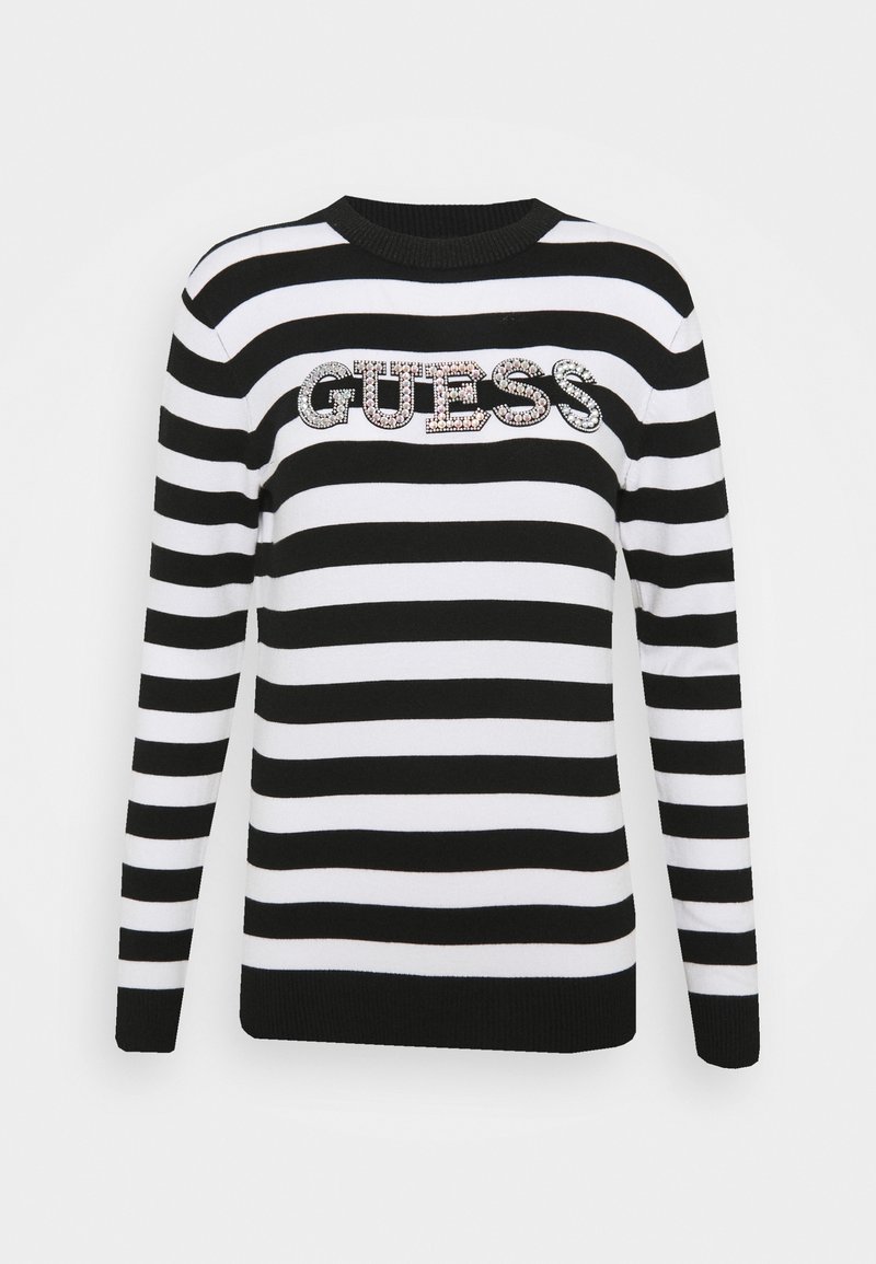 Pull rayé noir et blanc à manches longues, col côtelé, avec un logo "GUESS" en sequins sur la poitrine.