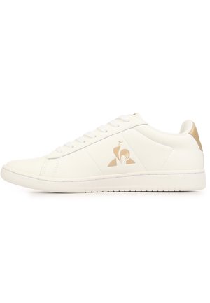 Sneaker bianca low-top con logo beige sul lato e dettaglio beige sul tallone, con design con lacci e suola piatta.