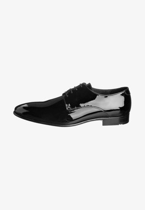 Chaussure habillée en cuir verni noir au design élégant, bout pointu, fermeture à lacets et finition lisse et brillante. Talon bas et rectangulaire.