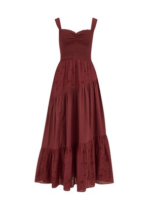Robe maxi bordeaux sans manches avec corsage froncé, jupe à volants, et broderie florale ajourée sur les volants supérieur et inférieur.