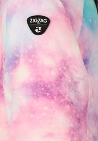 Gevoerde jas met een galaxieprint in pastelkleuren, voorzien van een zwart driehoekig logo-opdruk met de tekst "ZIGZAG" op de linkerschouder.