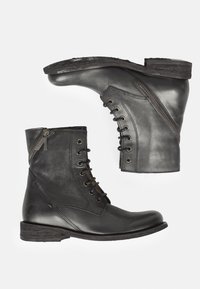 Stivaletti neri in pelle con una texture liscia, dotati di lacci frontali, zip laterale e tacco basso impilato.