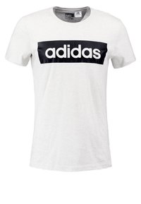 Camiseta de algodón blanca con escote redondo, que presenta un gran logotipo negro de "adidas" en la parte frontal. Mangas cortas, ajuste casual.