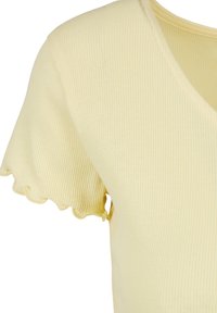 Haut à manches courtes en tissu côtelé jaune pâle avec des détails volantés aux manches et un décolleté en V.