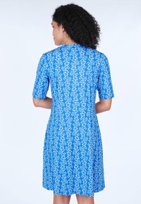 Blaues Kleid mit kurzen Ärmeln, florales Muster in Weiß und Hellblau; knielang, glatte Textur, figurbetontes Design mit rundem Ausschnitt.