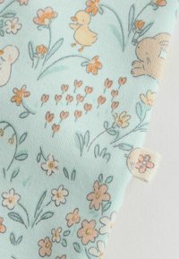 Tissu en coton avec un fond bleu clair présentant un motif floral, des illustrations de petits canards jaunes et de lapins marron ; finition texturée.