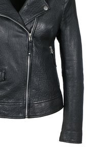 Schwarze strukturierte Lederjacke mit asymmetrischem silbernem Reißverschluss und seitlichem Reißverschlussfach, gezeigt von der Taille bis zur Mitte des Arms.