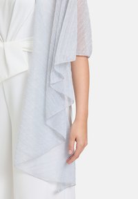 Kimono léger en bleu clair, transparent avec un bord festonné, dotée d'un subtil éclat. Le tissu présente un motif texturé à rayures horizontales.