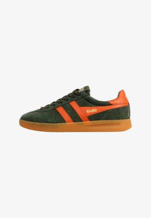 Donkergroene suède sneaker met oranje leren strepen en hiel, een gumzool en het "Gola"-logo aan de zijkant.