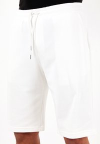 Hvide bomuldsshorts med elastisk talje, snøre lukning, sidelommer og en glat, mat overflade.
