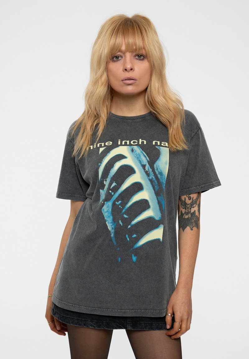 Gray cotton t-shirt featuring a large blue and white graphic print with text "nine inch nails." Round neckline and short sleeves.
