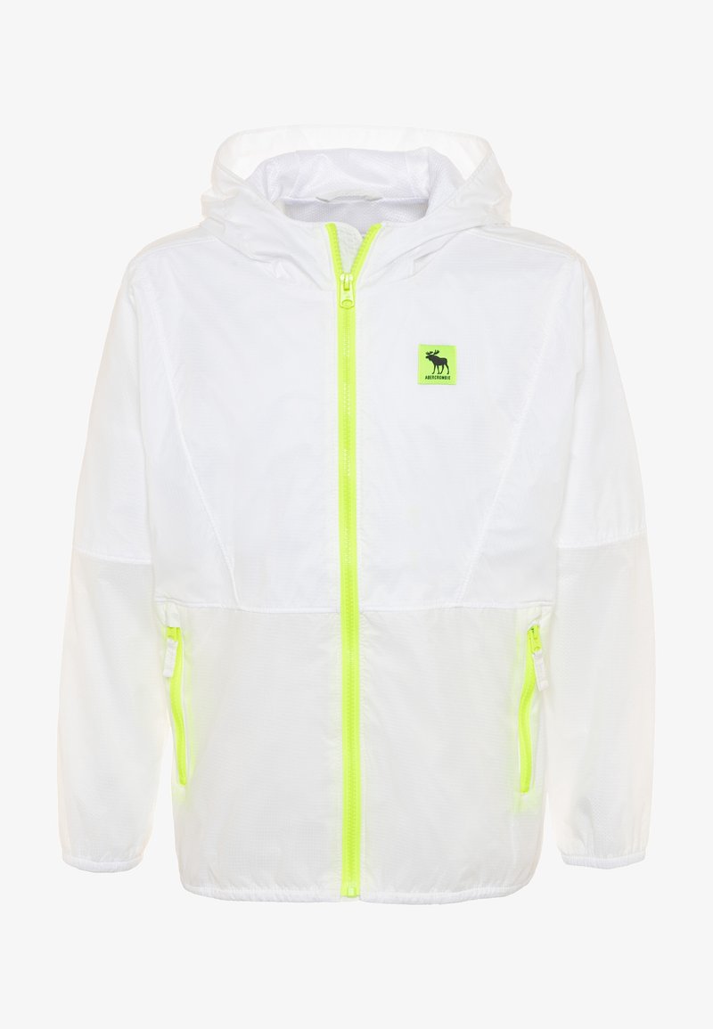 Giacca bianca con cappuccio, cerniera e dettagli delle tasche in giallo neon, con una piccola toppa con logo sul petto a sinistra.