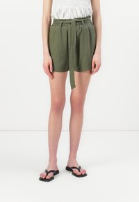 Shorts verts olive avec une coupe ample, une taille élastique et une ceinture à nouer. Fabriqués en tissu léger, dotés de poches avant et d'une texture lisse.