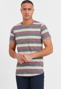 Striped T-shirt in beige, red, and navy blue, made of soft cotton. Features a crew neck and short sleeves, with a rounded hemline.