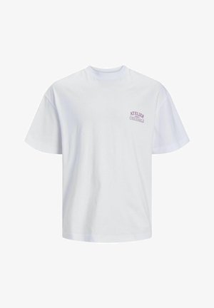 Valge puuvillane T-särk, millel on lõdva istuvus, lühikesed varrukad ja vasakul rinnal väike lilla logo, millel on kirjutatud "ATELIER ORIGINALS."