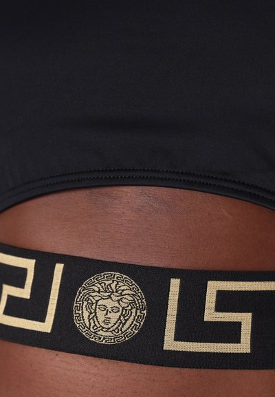 Μαύρη αθλητική μπλούζα με υφασμάτινη ζώνη που διαθέτει το χρυσό έμβλημα Μεδούσα και μοτίβο ελληνικού κλειδιού. Αδιαχώριστος σχεδιασμός για άνεση.