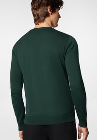 Ciemnozielony sweter dziany z długimi rękawami, ściągaczami przy mankietach i ściągaczem u dołu. Posiada klasyczny okrągły dekolt oraz lekko teksturowany materiał.