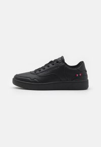 Black sneakers with a smooth leather finish, round toe, flat black sole, and subtle red, white, and blue accent on the side. Laced design.