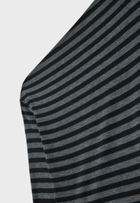 Zwart en grijs gestreepte stof; zachte textuur; lichte stretch. Bevat horizontale strepen van verschillende breedtes. De stof lijkt licht van gewicht.