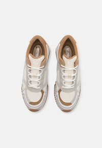Sneakers con lacci caratterizzati da una tomaia in mesh traspirante beige, dettagli in suede marrone e una suola in gomma marrone texture.